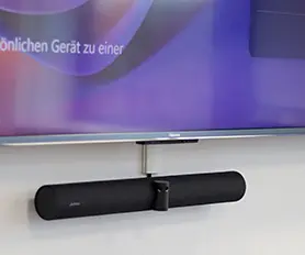 Lautsprecher unterhalb eines Bildschirms in einem Meetingraum