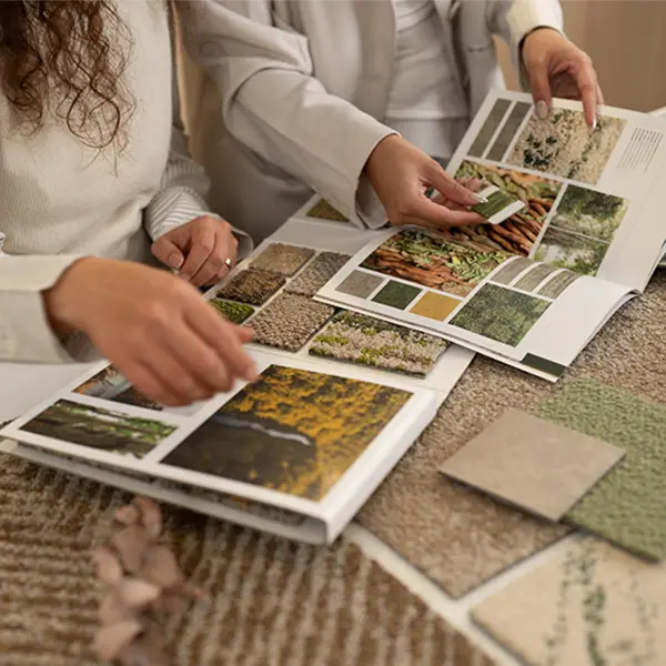 Zwei Personen an einem Musterbuch für Teppichfliesen