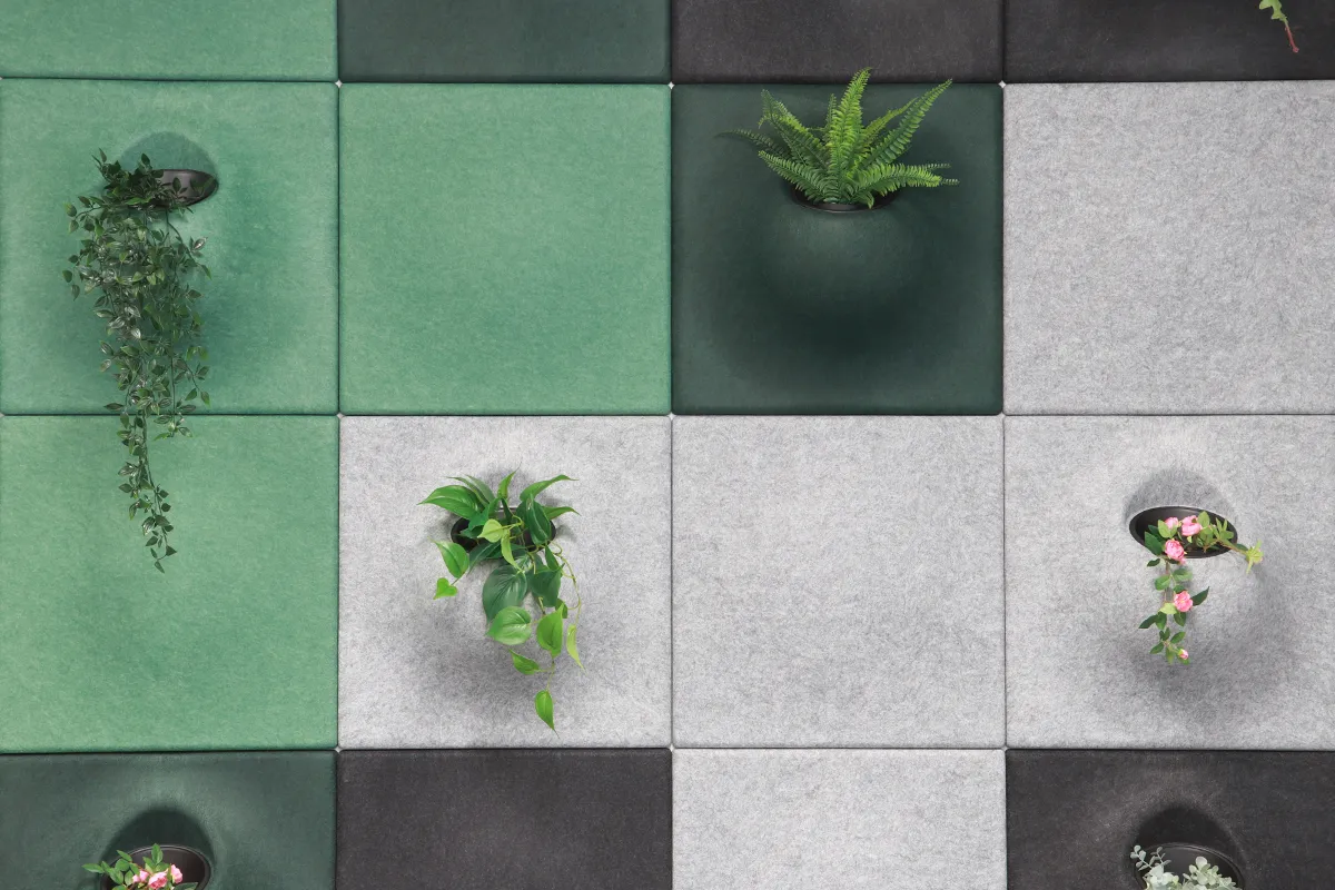 Nahaufnahme von PET Wandakustik in Grün und Grau mit Pflanzeinsätzen